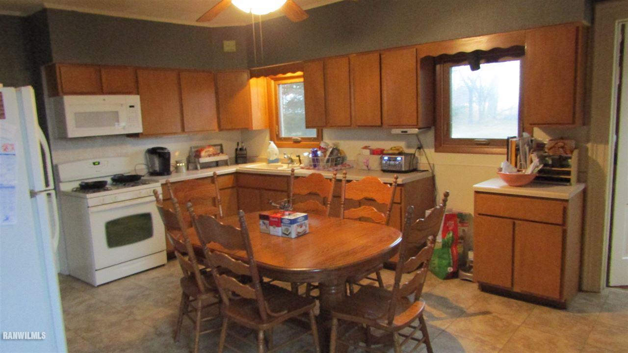 11693 Maple Grove Road Lanark, IL 61046 - Photo 3 of 19 a kitchen with a dining table chairs and refrigerator
