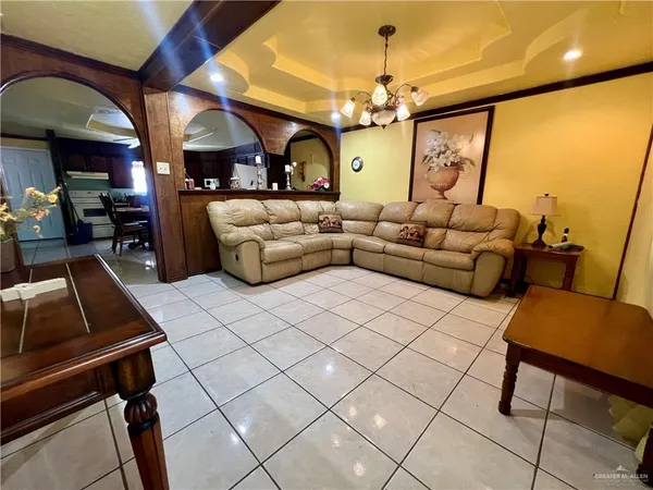a living room with furniture a chandelier and a flat screen tv