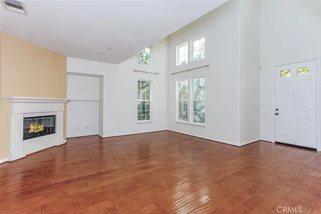 an empty room with windows and fireplace