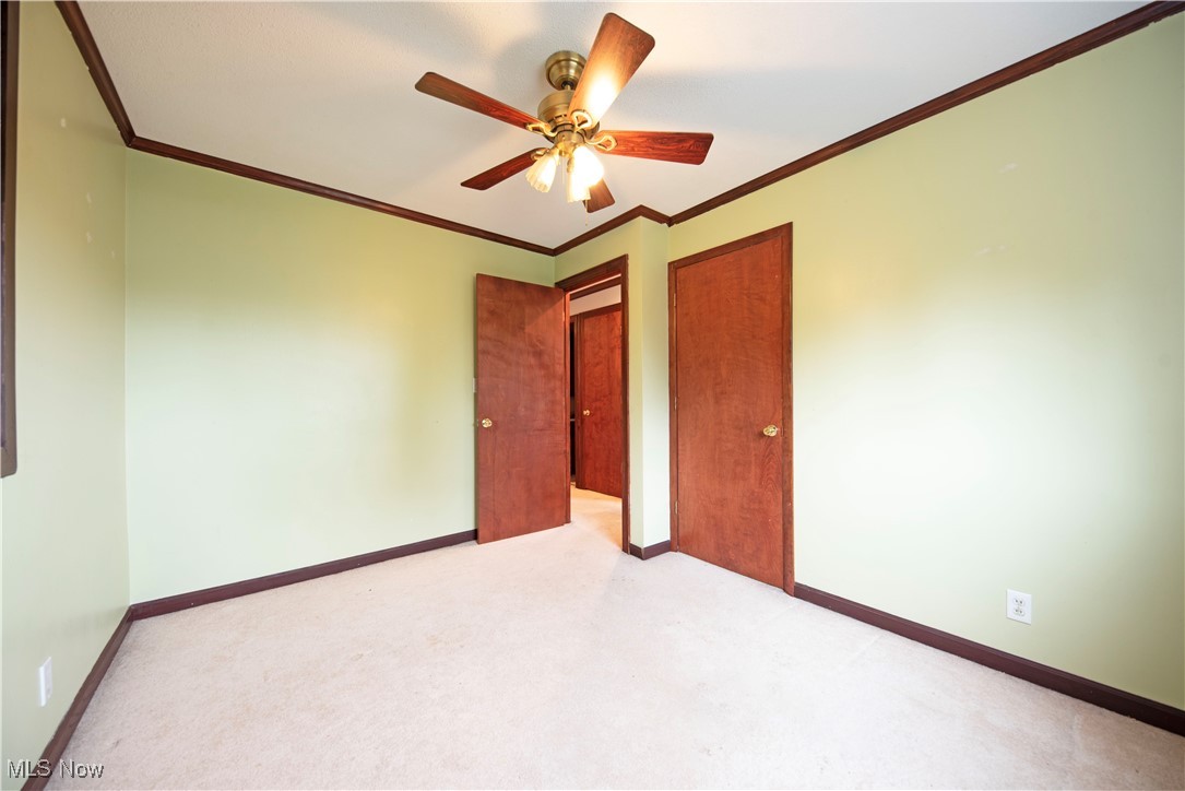 2501 East Pleasant Valley Road Independence, OH 44131 - Photo 21 of 29 Unfurnished bedroom with ornamental molding, ceiling fan, and light colored carpet