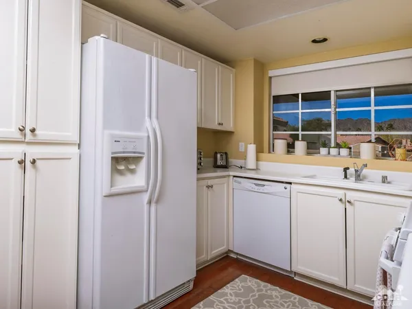 a kitchen with white cabinets and refrigerator