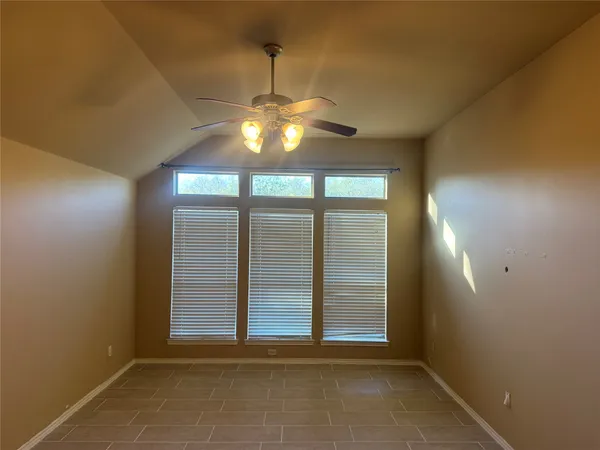 an empty room with chandelier fan