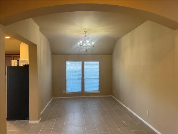 a view of a room with a chandelier fan and windows