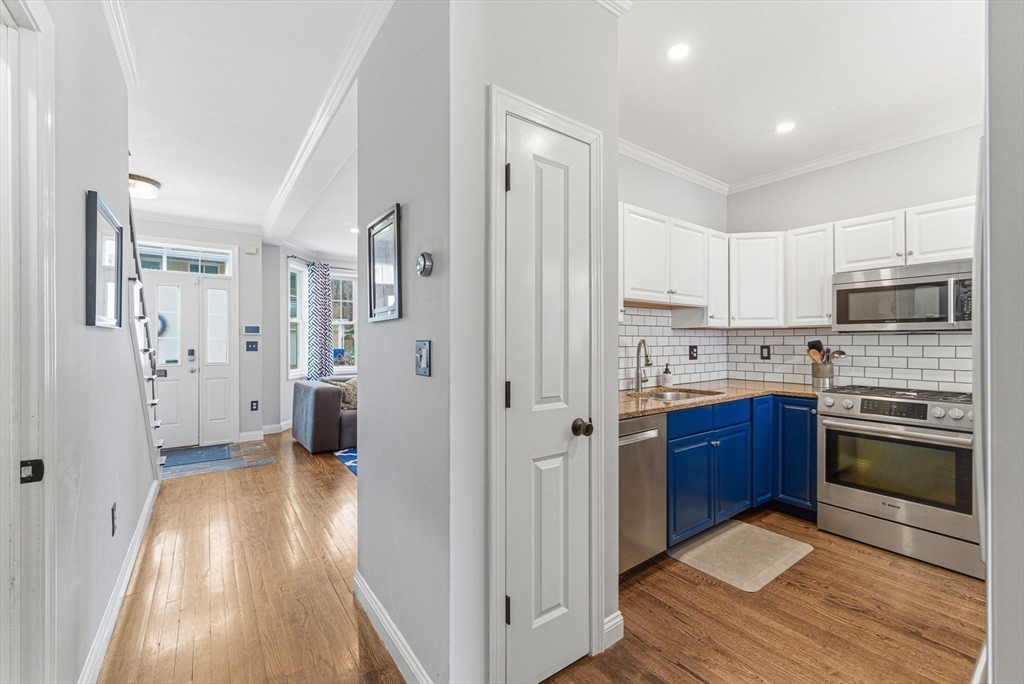 6 Millmont Street, Unit 6 Boston, MA 02119 - Photo 11 of 42 a kitchen with stainless steel appliances granite countertop a refrigerator and a stove top oven