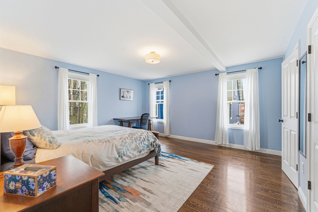 6 Millmont Street, Unit 6 Boston, MA 02119 - Photo 23 of 42 a bedroom with a bed and wooden floor