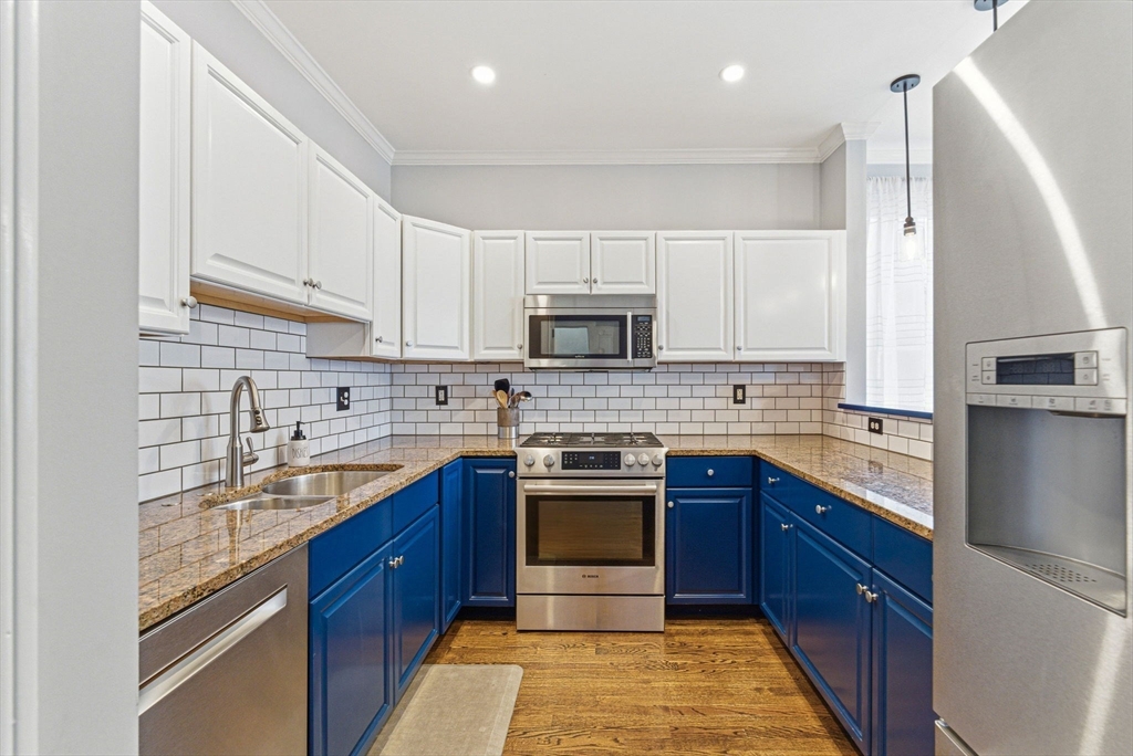 6 Millmont Street, Unit 6 Boston, MA 02119 - Photo 10 of 42 a kitchen with stainless steel appliances granite countertop a sink stove and refrigerator