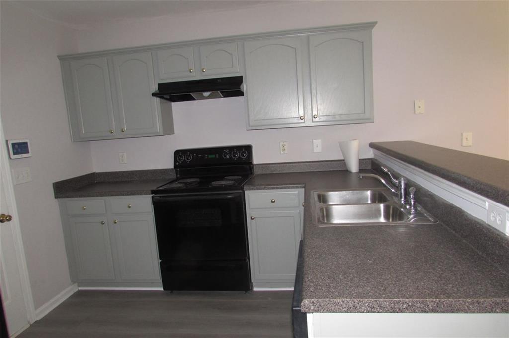 7238 April Court Morrow, GA 30260 - Photo 3 of 11 a kitchen with granite countertop white cabinets and black appliances