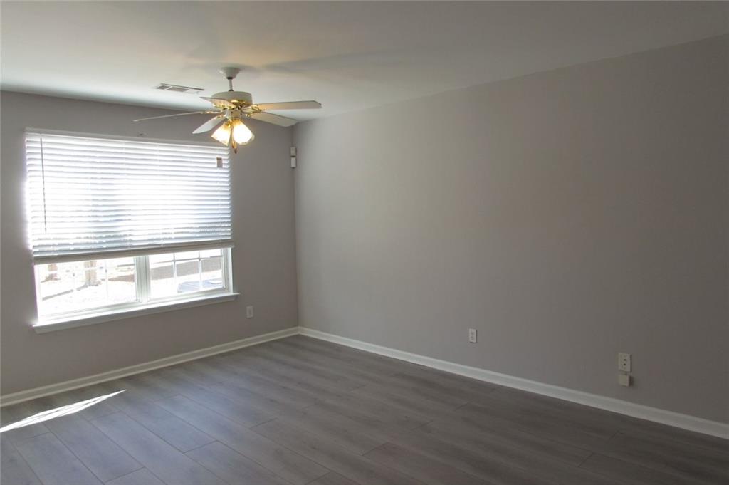 7238 April Court Morrow, GA 30260 - Photo 7 of 11 an empty room with wooden floor fan and windows