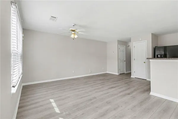 a view of a kitchen with a refrigerator a ceiling fan and wooden floor