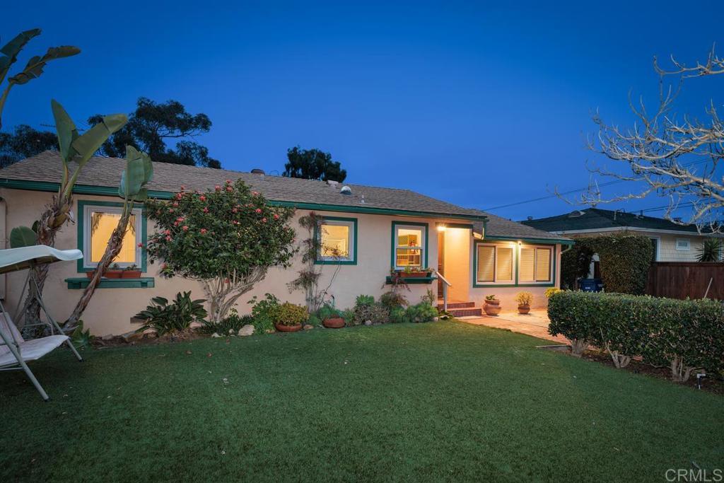 a front view of a house with a garden and yard
