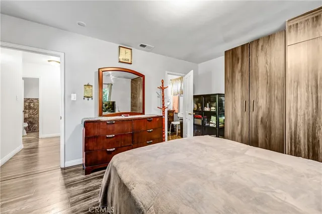 a bedroom with a bed and a mirror on dresser