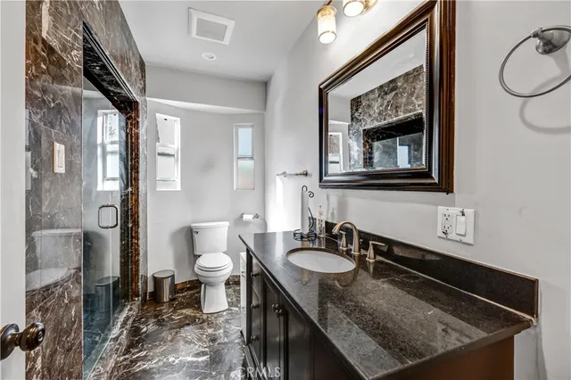 a bathroom with a sink a toilet and a mirror