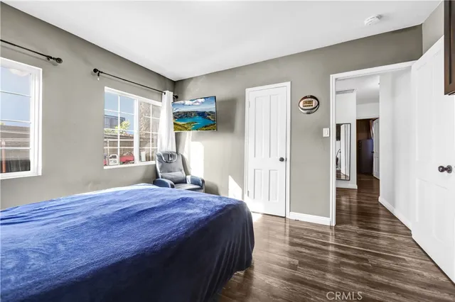 a spacious bedroom with a bed and wooden floor