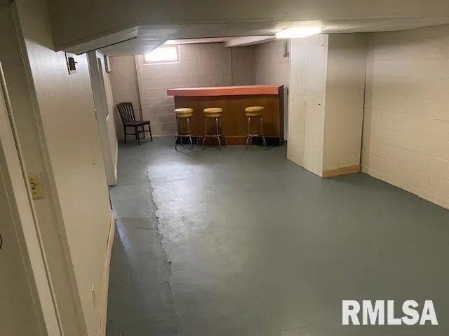 a view of a white house next to a yard with big trees