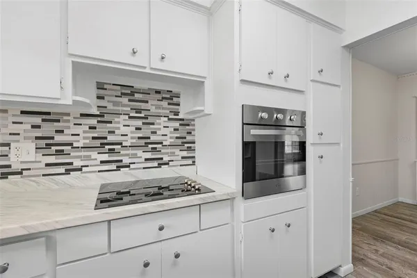 a kitchen with white cabinets and appliances