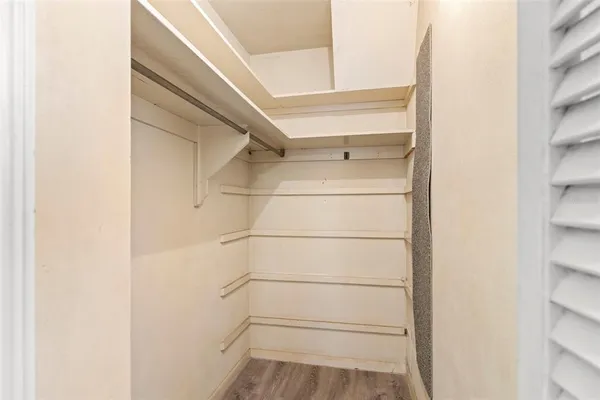 a view of walk in closet with empty racks