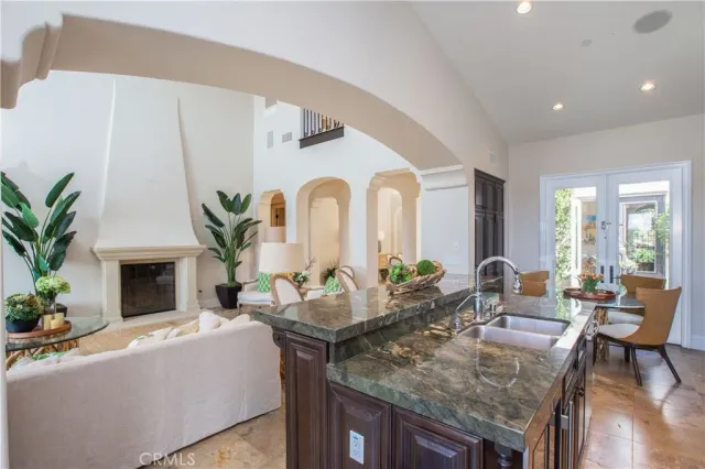a living room with fireplace furniture and potted plants