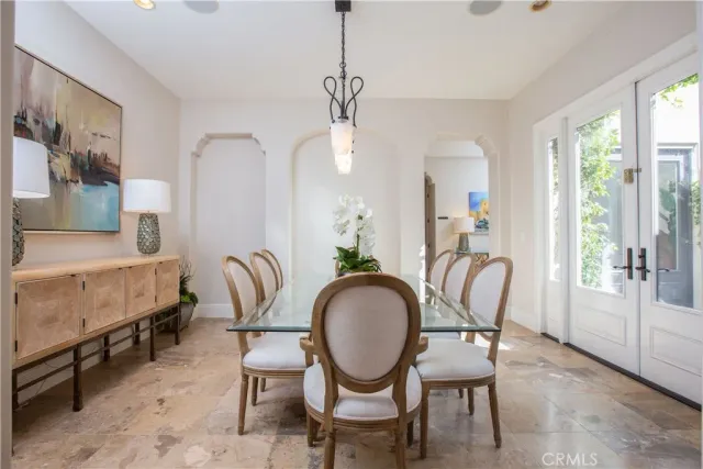 a dining room with furniture a rug a potted plant and a chandelier