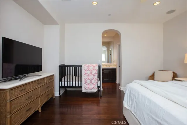 a bedroom with a large bed and a chandelier