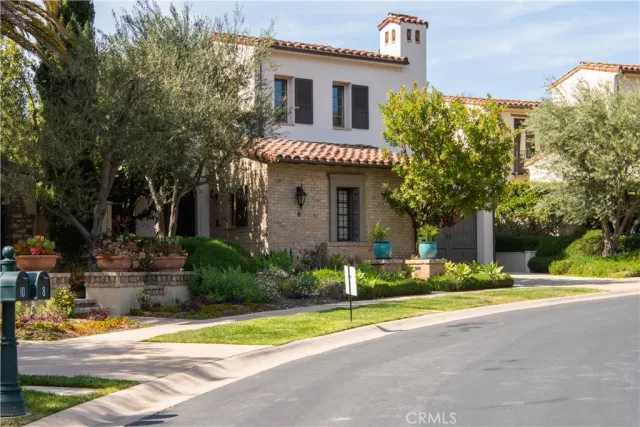a front view of a house with a yard and potted plants
