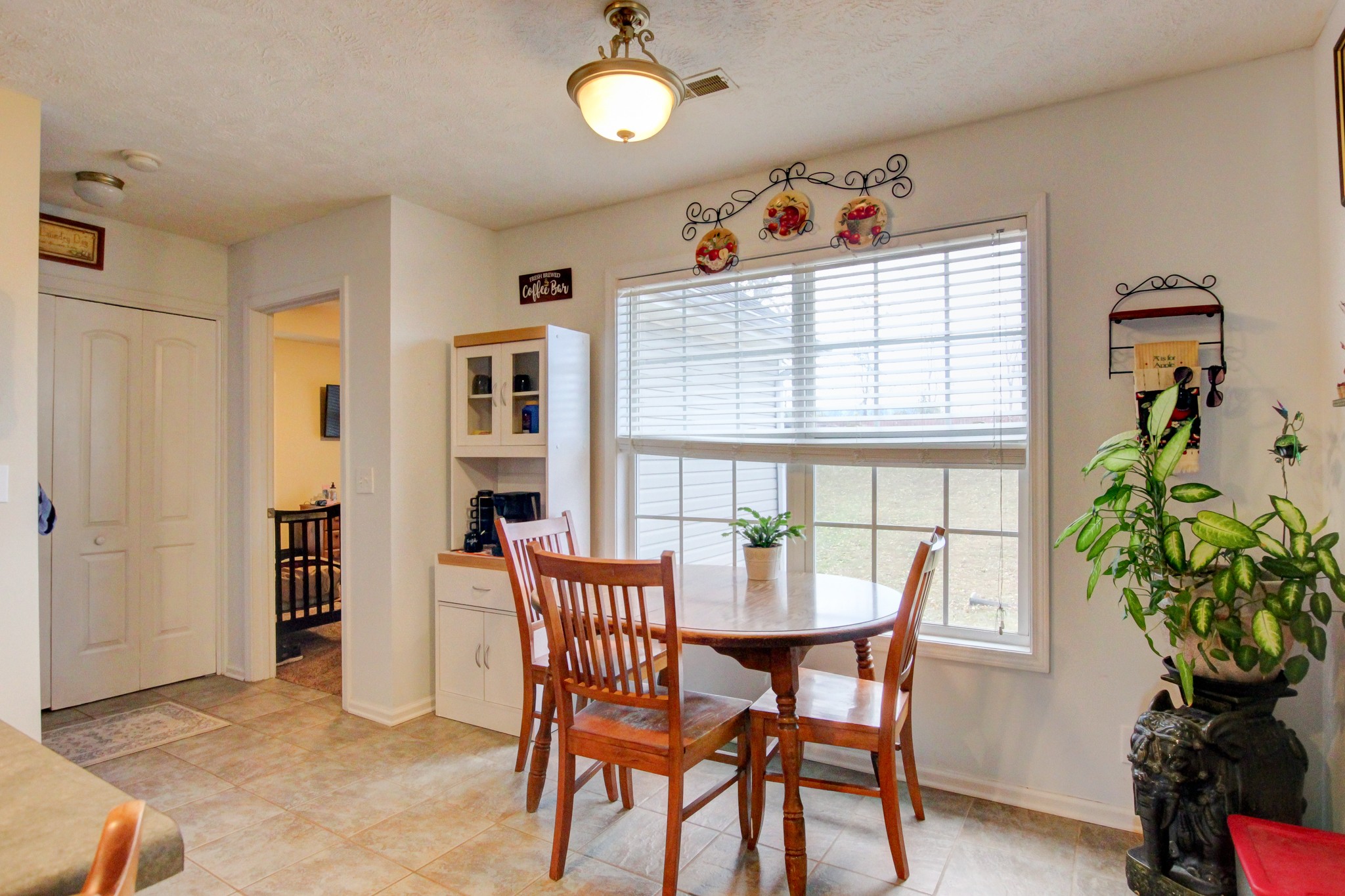 244 Cheshire Road Clarksville, TN 37043 - Photo 31 of 84 a dining room with furniture potted plants and wooden floor