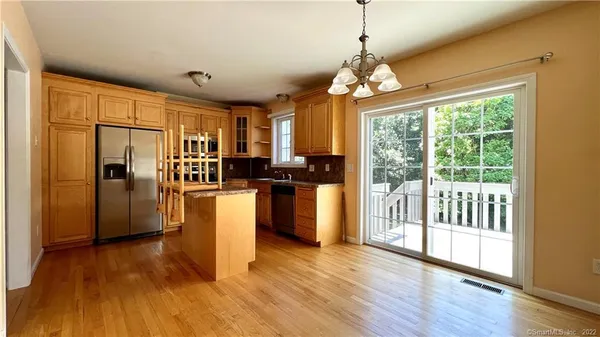 a kitchen with stainless steel appliances granite countertop a refrigerator a stove a sink dishwasher a refrigerator with wooden floor