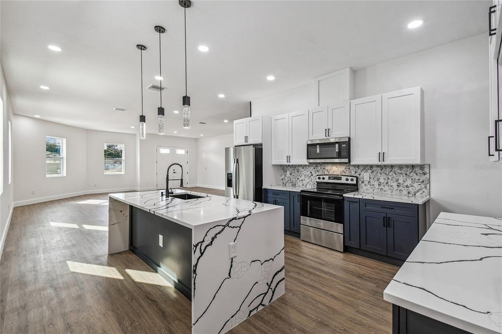 310 Waterfall Drive Spring Hill, FL 34608 - Photo 12 of 40 a large kitchen with stainless steel appliances granite countertop a stove and a wooden floors