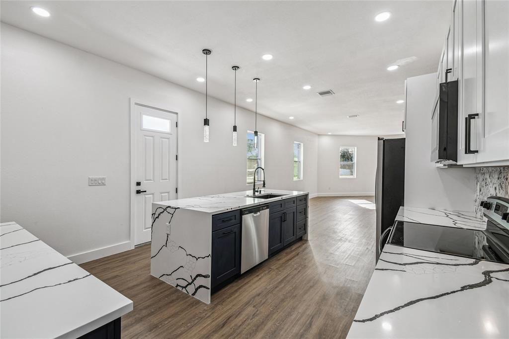 310 Waterfall Drive Spring Hill, FL 34608 - Photo 13 of 40 a large kitchen with stainless steel appliances a large counter top a sink a stove and a refrigerator