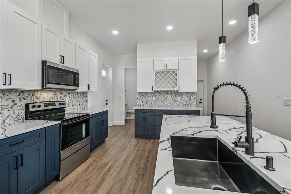 310 Waterfall Drive Spring Hill, FL 34608 - Photo 14 of 40 a kitchen with a sink stainless steel appliances and cabinets