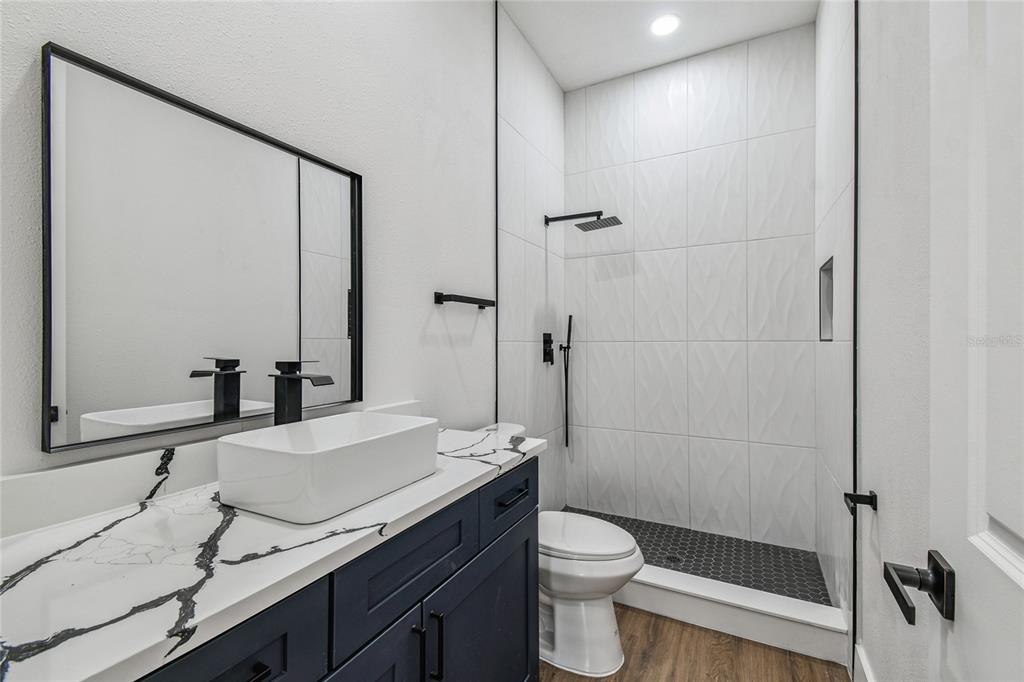 310 Waterfall Drive Spring Hill, FL 34608 - Photo 18 of 40 a bathroom with a granite countertop sink toilet and shower