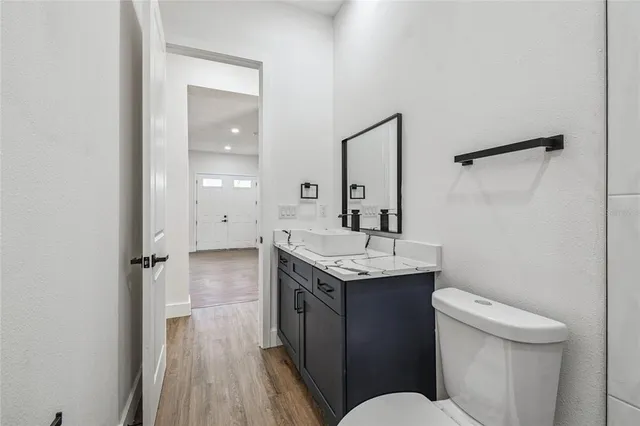 a bathroom with a sink a toilet a mirror and shower