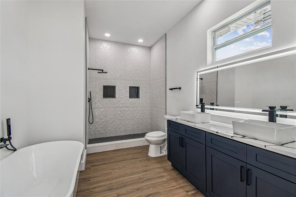 310 Waterfall Drive Spring Hill, FL 34608 - Photo 27 of 40 a bathroom with a double vanity sink a toilet and a large mirror