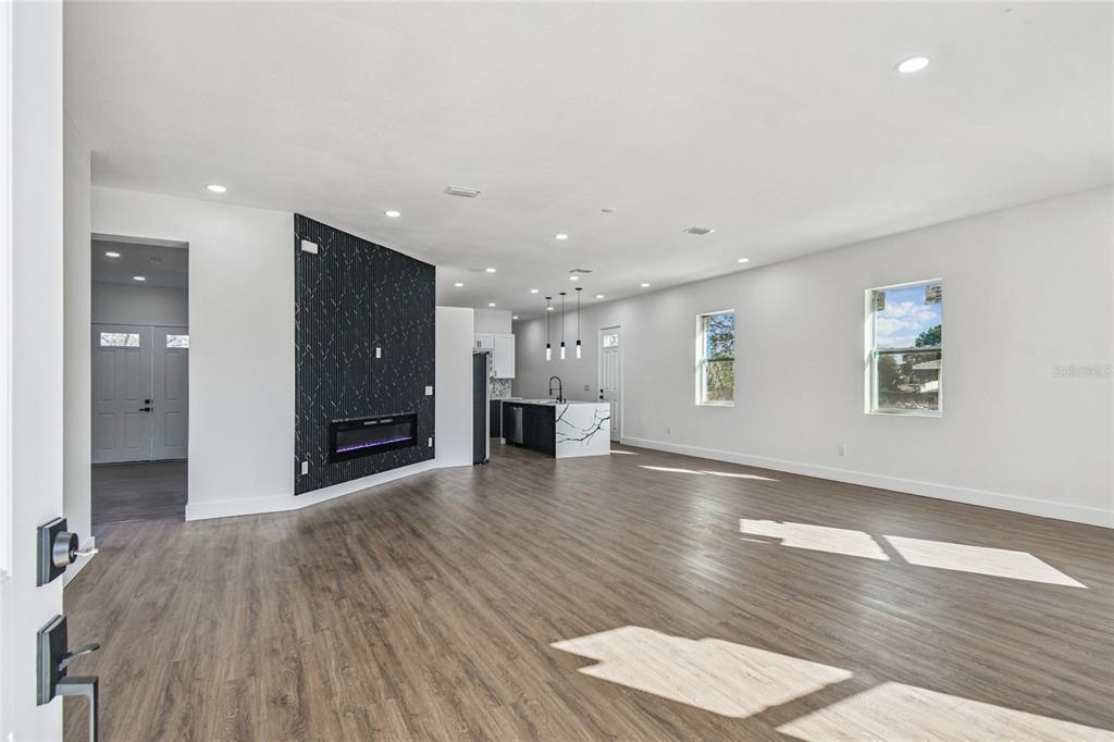 310 Waterfall Drive Spring Hill, FL 34608 - Photo 5 of 40 a view of an empty room with wooden floor and a window