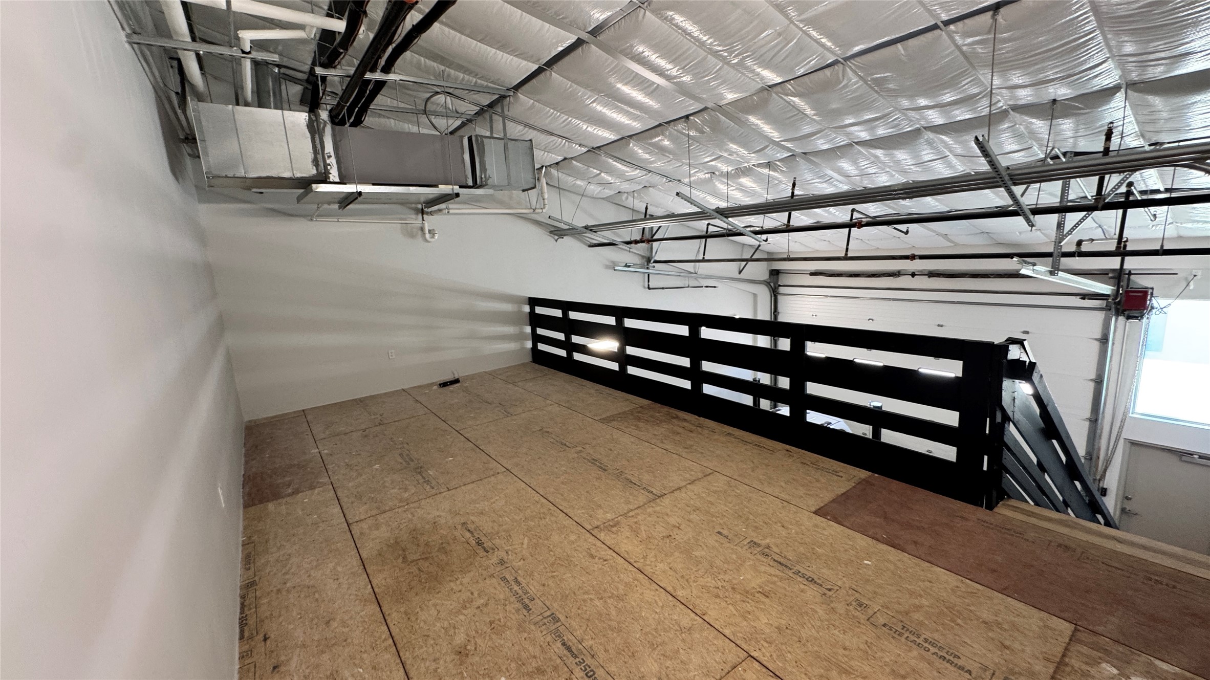 1009 Ranch Road 620 North, Unit 401 Lakeway, TX 78734 - Photo 8 of 15 A spacious industrial loft offers exposed ductwork and a robust railing system overlooking the main area.