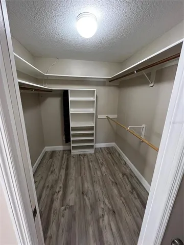 a view of walk in closet with wooden floor