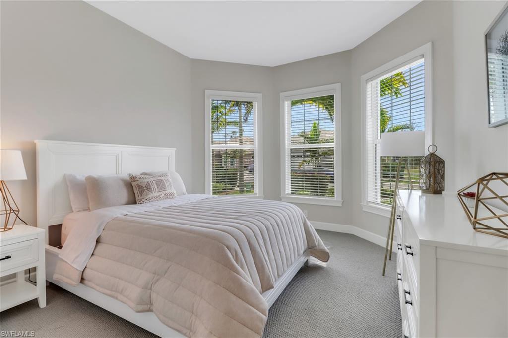 6299 Arriba Avenue Naples, FL 34113 - Photo 12 of 26 Bedroom with light colored carpet and baseboards