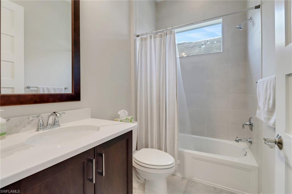 6299 Arriba Avenue Naples, FL 34113 - Photo 14 of 26 Full bath with tile patterned floors, vanity, toilet, and shower / tub combo with curtain