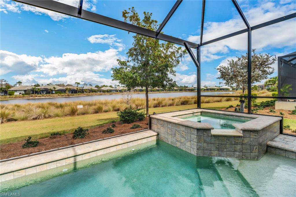 6299 Arriba Avenue Naples, FL 34113 - Photo 2 of 26 View of swimming pool with an in ground hot tub, a yard, a water view, and glass enclosure
