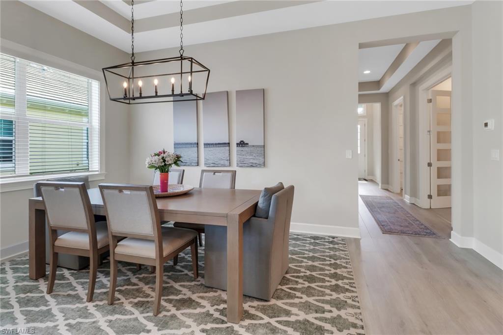 6299 Arriba Avenue Naples, FL 34113 - Photo 5 of 26 Dining area with recessed lighting, a raised ceiling, baseboards, and wood finished floors