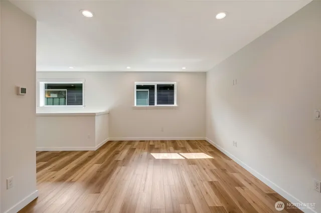 an empty room with a fireplace and wooden floor