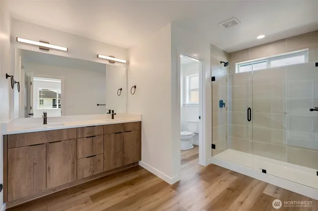 a spacious bathroom with a shower sink and mirror