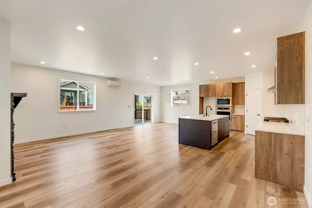 an open kitchen with kitchen island wooden floor and center island