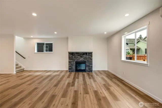 an empty room with windows and a fireplace