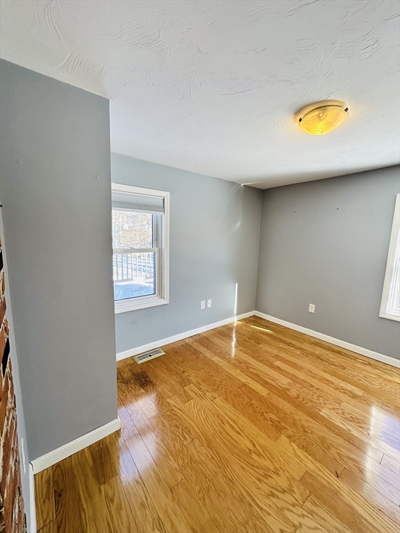 82 East High Street, Unit 1 Avon, MA 02322 - Photo 12 of 21 a bedroom with a bed and a painting on the wall