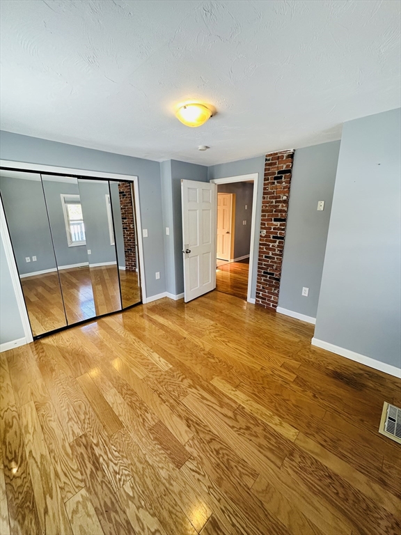 82 East High Street, Unit 1 Avon, MA 02322 - Photo 14 of 21 a view of empty room with wooden floor and fan