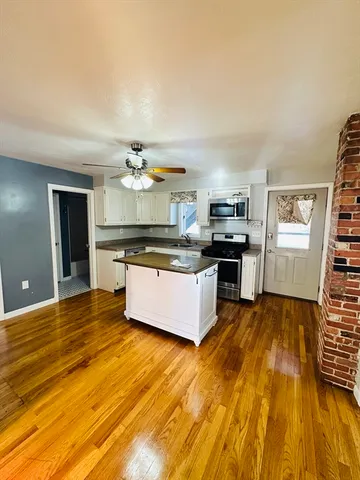 a large kitchen with stainless steel appliances granite countertop a stove and a sink