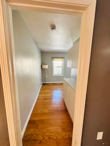 a view of hallway with wooden floor and staircase