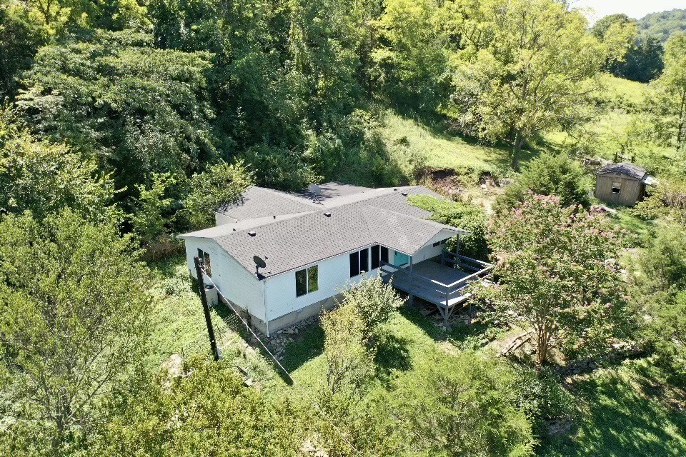 an aerial view of a house with yard and roof