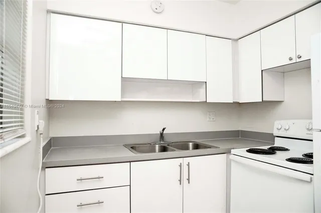 a white refrigerator freezer and a stove sitting inside of a kitchen