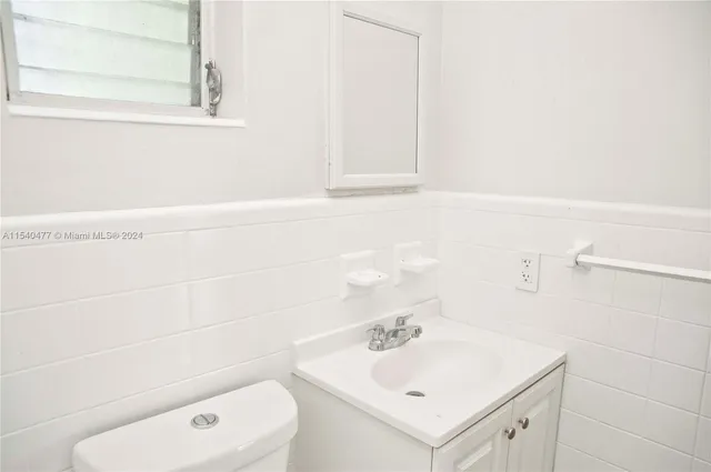 a bathroom with a sink a toilet and mirror